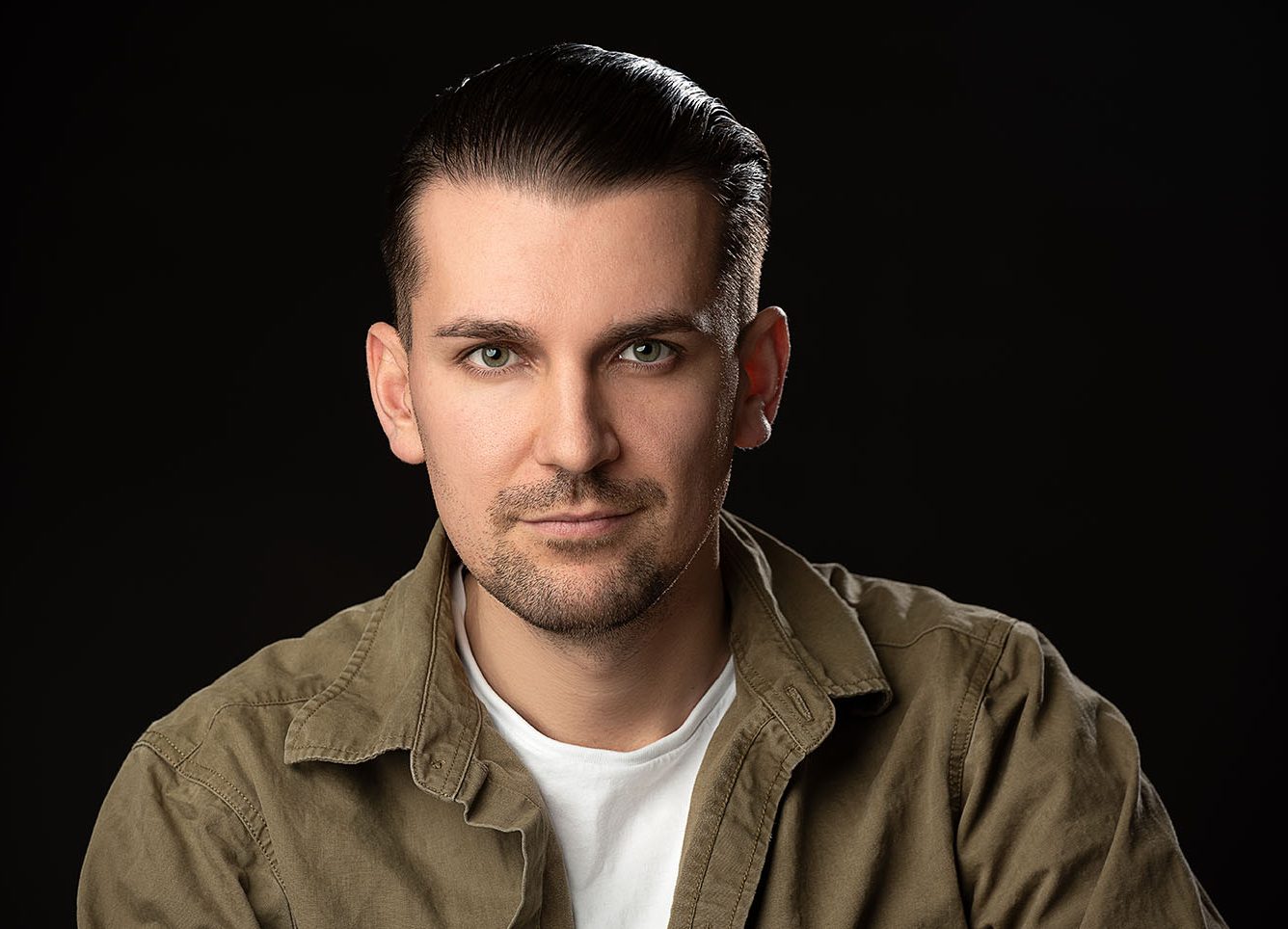 Ausdrucksstarkes Portrait eines Mannes mit professioneller Studiobeleuchtung und dunklem Hintergrund im Fotostudio Würzburg.