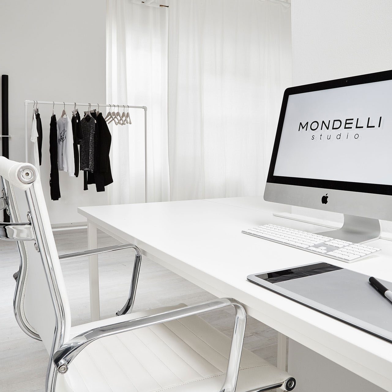 Professioneller Bildbearbeitungsplatz im Mietstudio mit iMac und Grafiktablett, inklusive Kleiderstange für Model-Stylings.