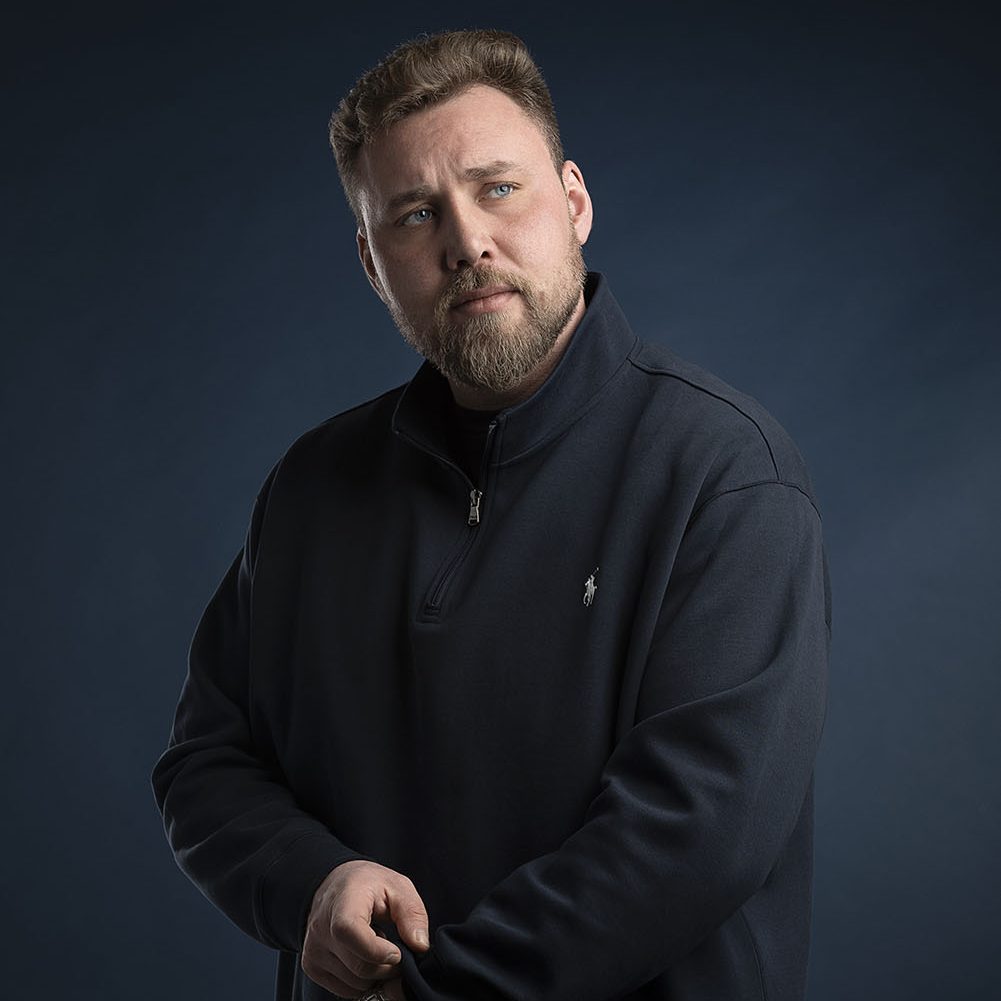Charakterstarkes Männerportrait vor dunklem Hintergrund mit markanter Lichtsetzung, aufgenommen im Portraitstudio Würzburg.